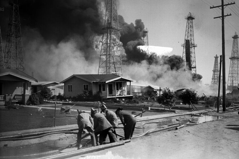 Sept. 19, 1928: Firefighters lay hoses to protect homes from an oil well fire in Santa Fe Springs. Firefighters laying hoses to protect homes from oil well fires in Santa Fe Springs, Calif. Dated Sept 19, 1928. Los Angeles Times Photographic Archive/UCLA. Image has some emulsion damage. Scanned from glass negative.