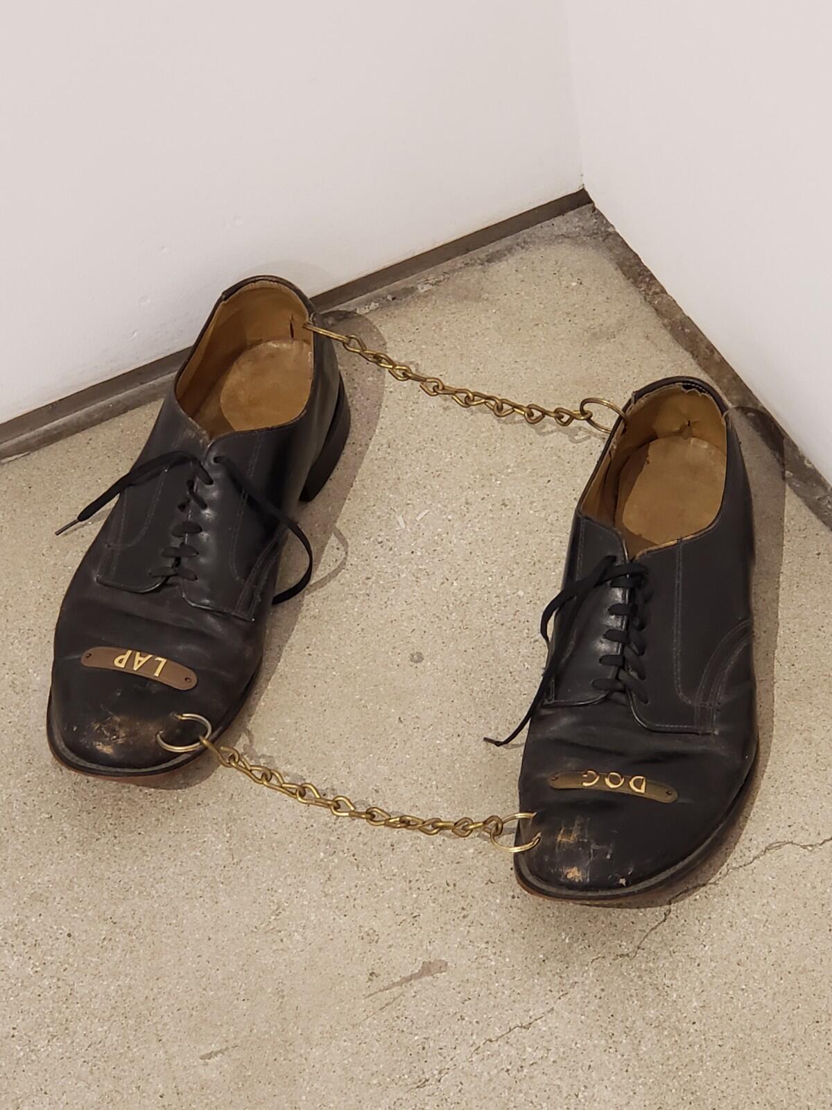 Nayland Blake, "Lap Dog," 1987; leather shoes, brass plates, chain