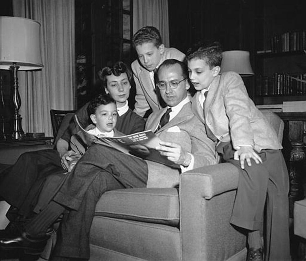 Dr. Jonas Salk reads Life magazine with his wife and three boys. From left are Jonathan, 5; Donna Salk; Peter, 11; Jonas Salk; and Darrell, 8.