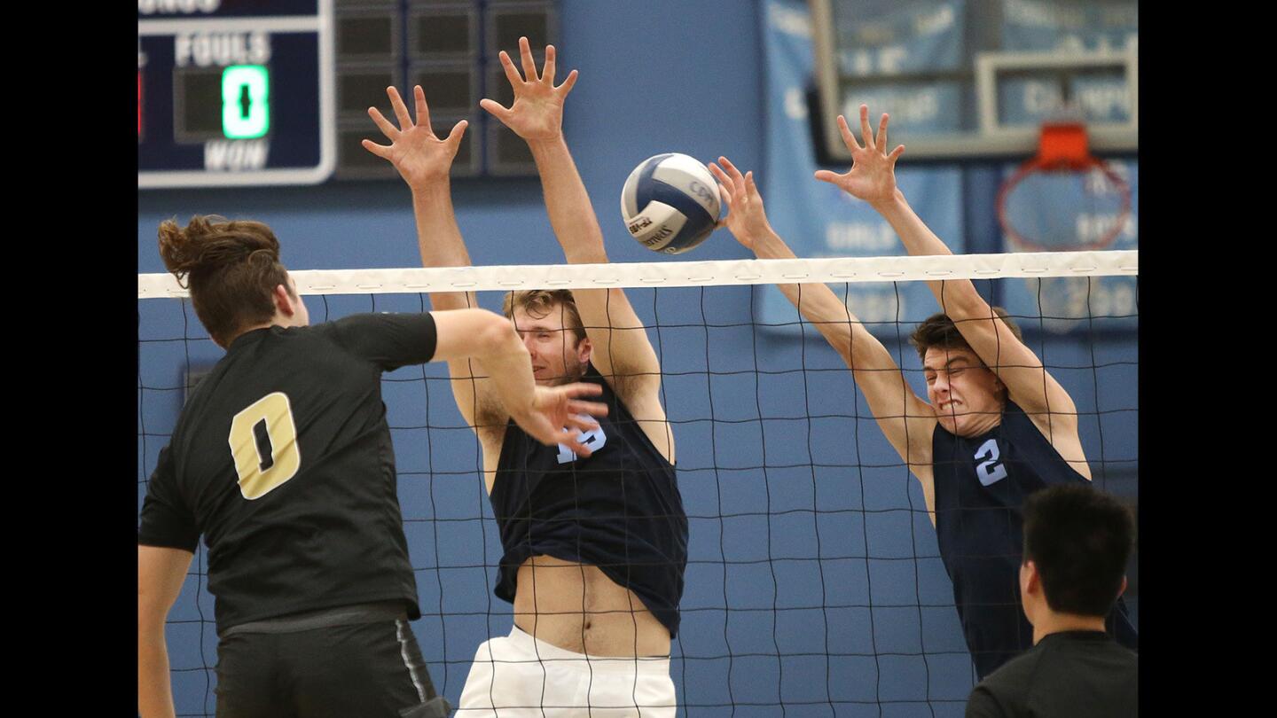 Corona del Mar blockers Brandon Hicks (19) and Tyler Flood (2) block the kill of Adam Chang during the opening round of the CIF Southern California Regional Division I playoffs at Corona del Mar on Tuesday.