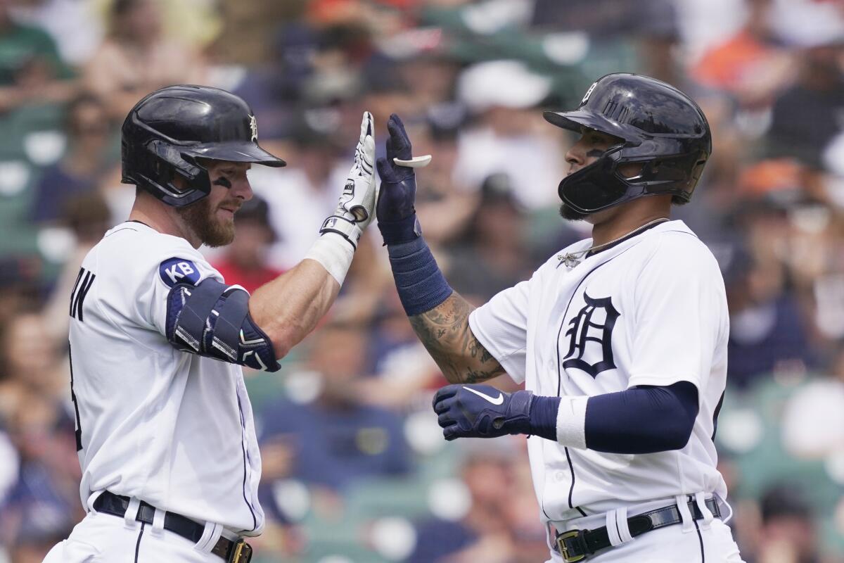 Detroit Tigers' Javier Baez, right, is greeted at home plate by teammate Robbie Grossman after scoring during the fourth inning of a baseball game against the Minnesota Twins, Sunday, July 24, 2022, in Detroit. (AP Photo/Carlos Osorio)