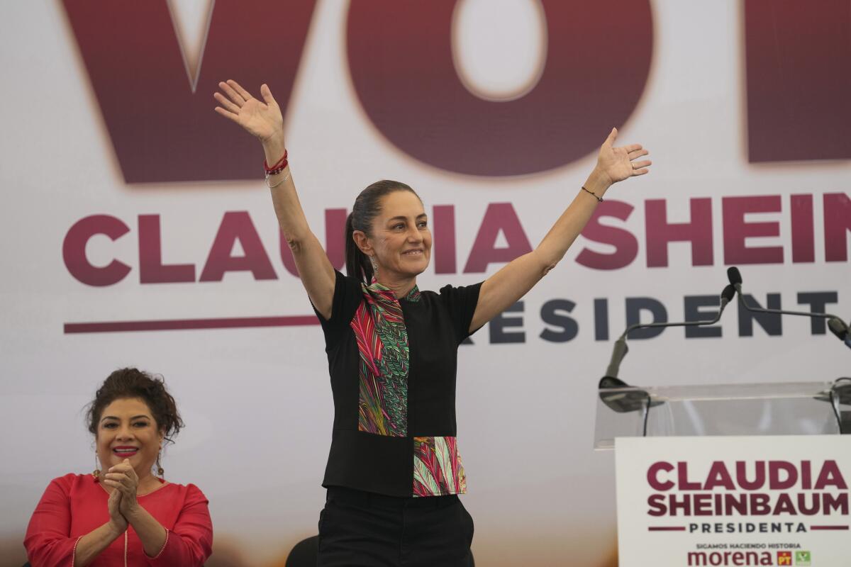 Claudia Sheinbaum waves onstage at a campaign event.