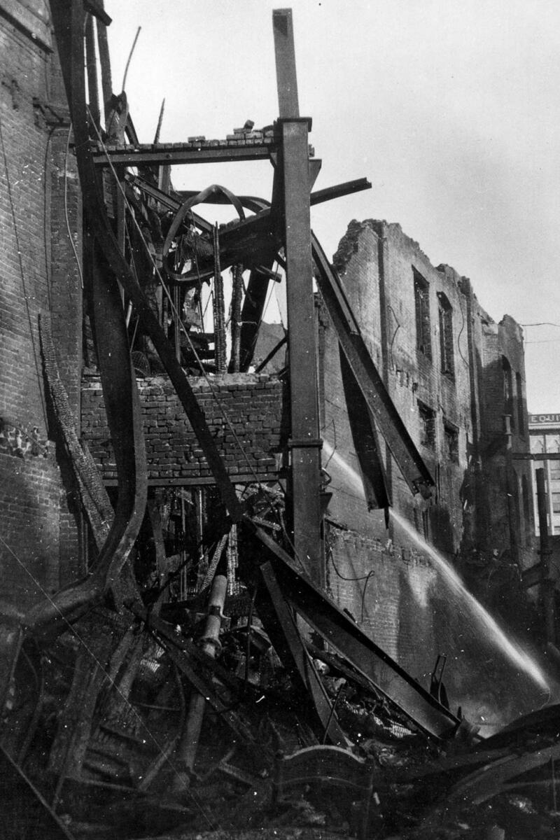 A black-and-white closeup of a building's mangled remains