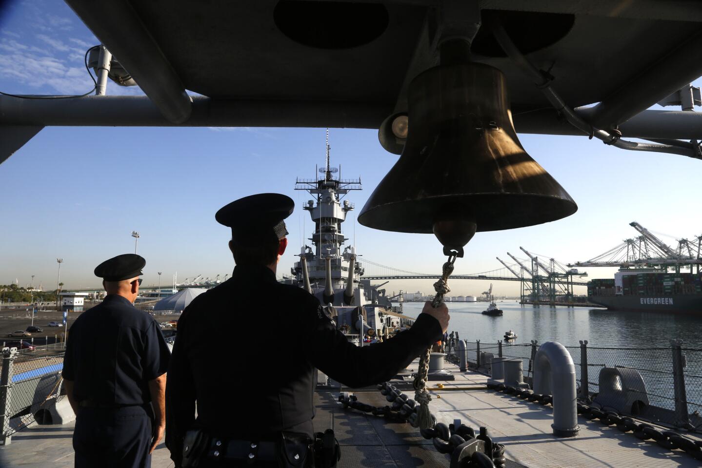 Los Angeles Port Police Officer Stacey J. Creech rings the ship's bell aboard the USS Iowa in San Pedro after the names of 40 first responders who died during 911 were read during a ceremony marking the 14th anniversary of the attacks September 11th.
