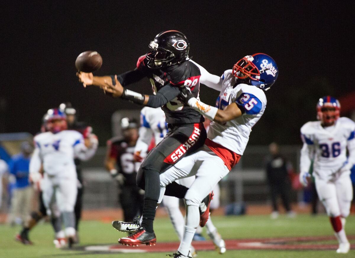 Serra receiver Cameron Hayes pulls Corona Centennial defensive back Javon McKinley away from a potential interception during a playoff game.