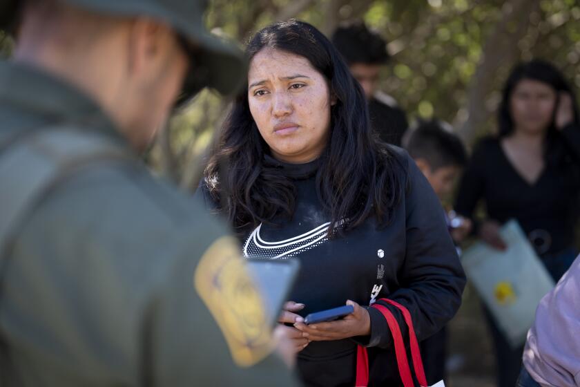 Una migrante de México habla con un agente de la Patrulla Fronteriza previo a ser transportada en una camioneta para ser procesada para el asilo, el miércoles 5 de junio de 2024, cerca de Dulzura, California. (AP Foto/Gregory Bull)