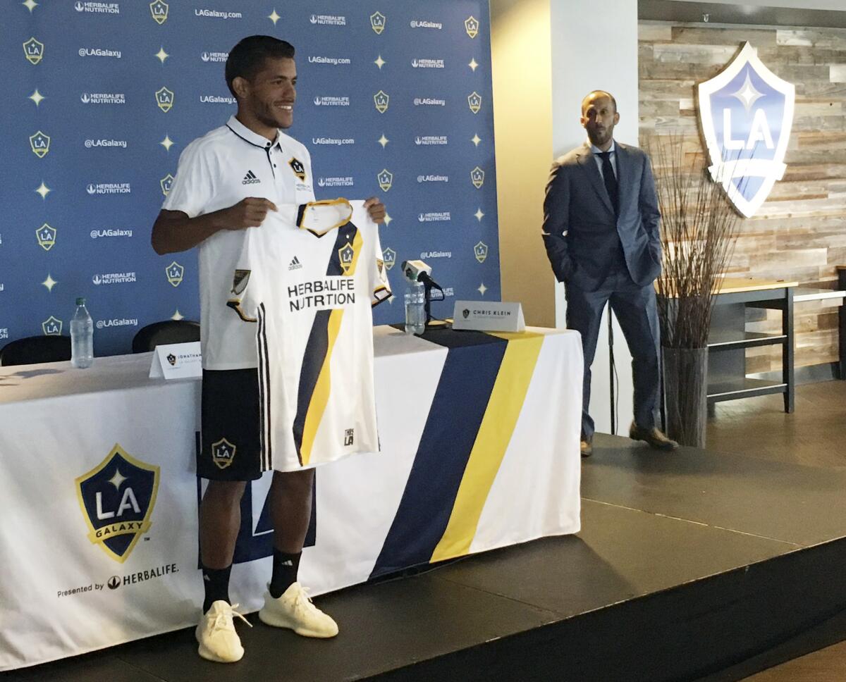 Jonathan dos Santos del Galaxy de Los Angeles sostiena una camiseta tras ser presentado por el equipo en Carson, California, el viernes 28 de julio de 2017.