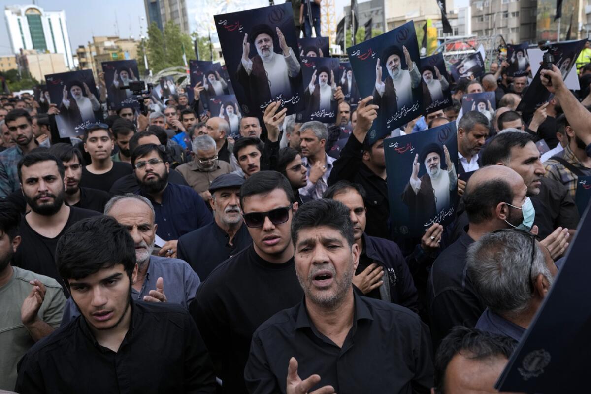 La gente sostiene carteles del presidente iraní 