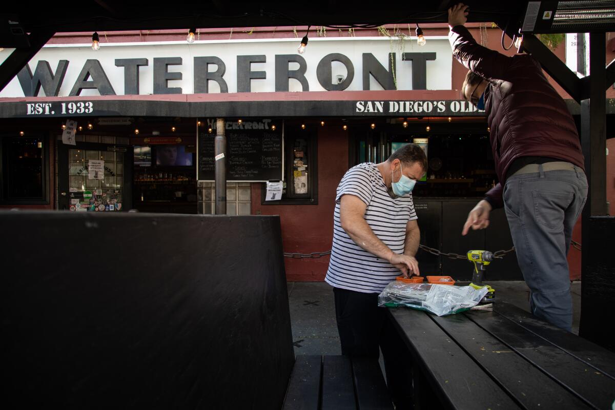 People install heaters at an outdoor restaurant