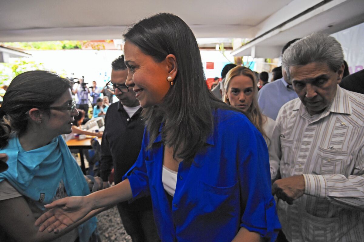 Venezuelan opposition leader Maria Corina Machado speaks with supporters after a news conference. She denied accusations of involvement in a conspiracy to murder the nation’s president.