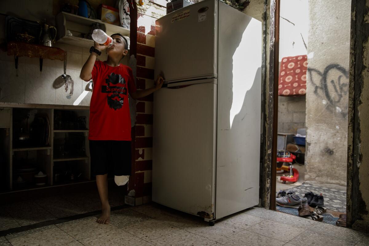 Abdel-Rahman Nofal bebe agua en su casa después de jugar fútbol. (Marcus Yam / Los Angeles Times)