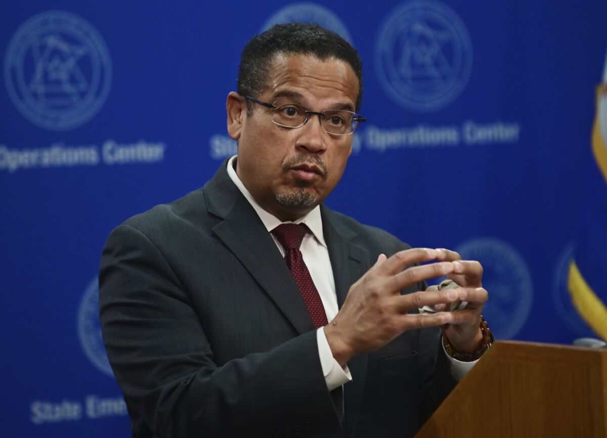 A person gestures with his hand at a lectern.