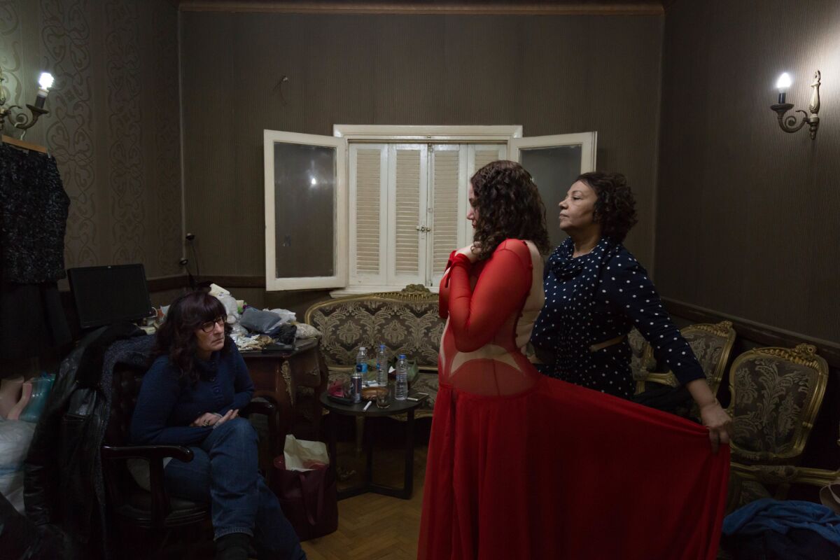 Eman Zaki inspects a costume during a fitting for American belly dancer Amity Alize. (Sima Diab / For The Times)