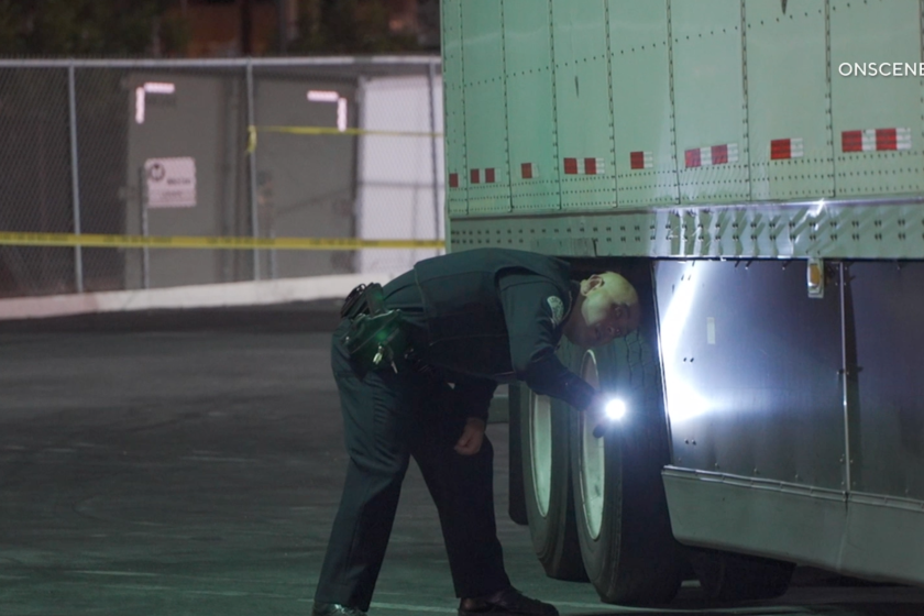 LAPD officers inspect a big-rig that ran over a woman sleeping at a Vons parking lot in Echo Park.