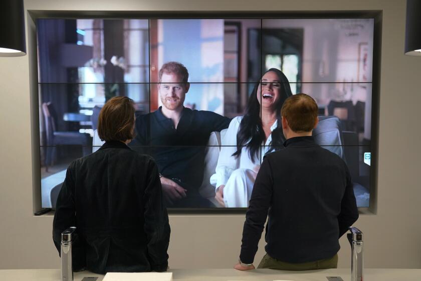 Empleados de oficina en Londres miran el controvertido documental de los duques de Sussex, Enrique y Meghan, emitido por Netflix, jueves 8 de diciembre de 2022. El primero de los tres episodios se emitió el jueves. (Jonathan Brady/PA via AP)