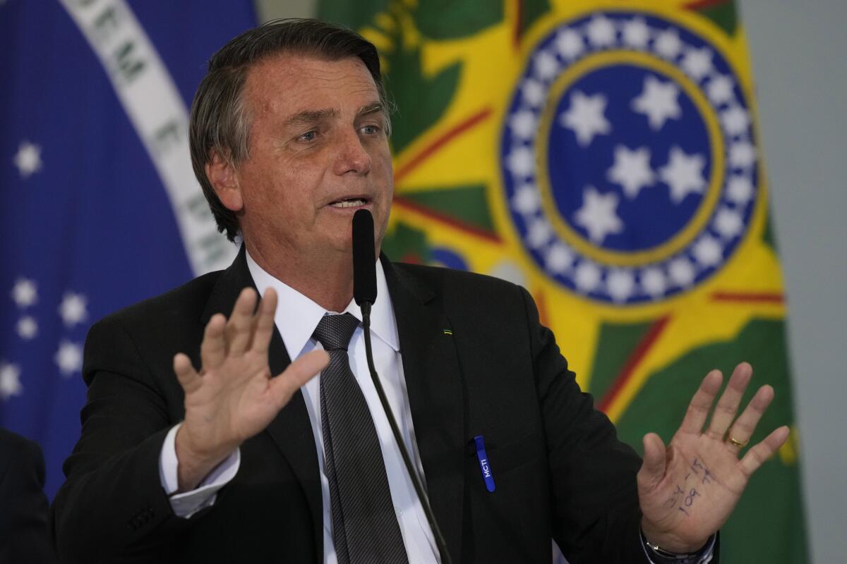 Brazil's President Jair Bolsonaro speaks at a microphone