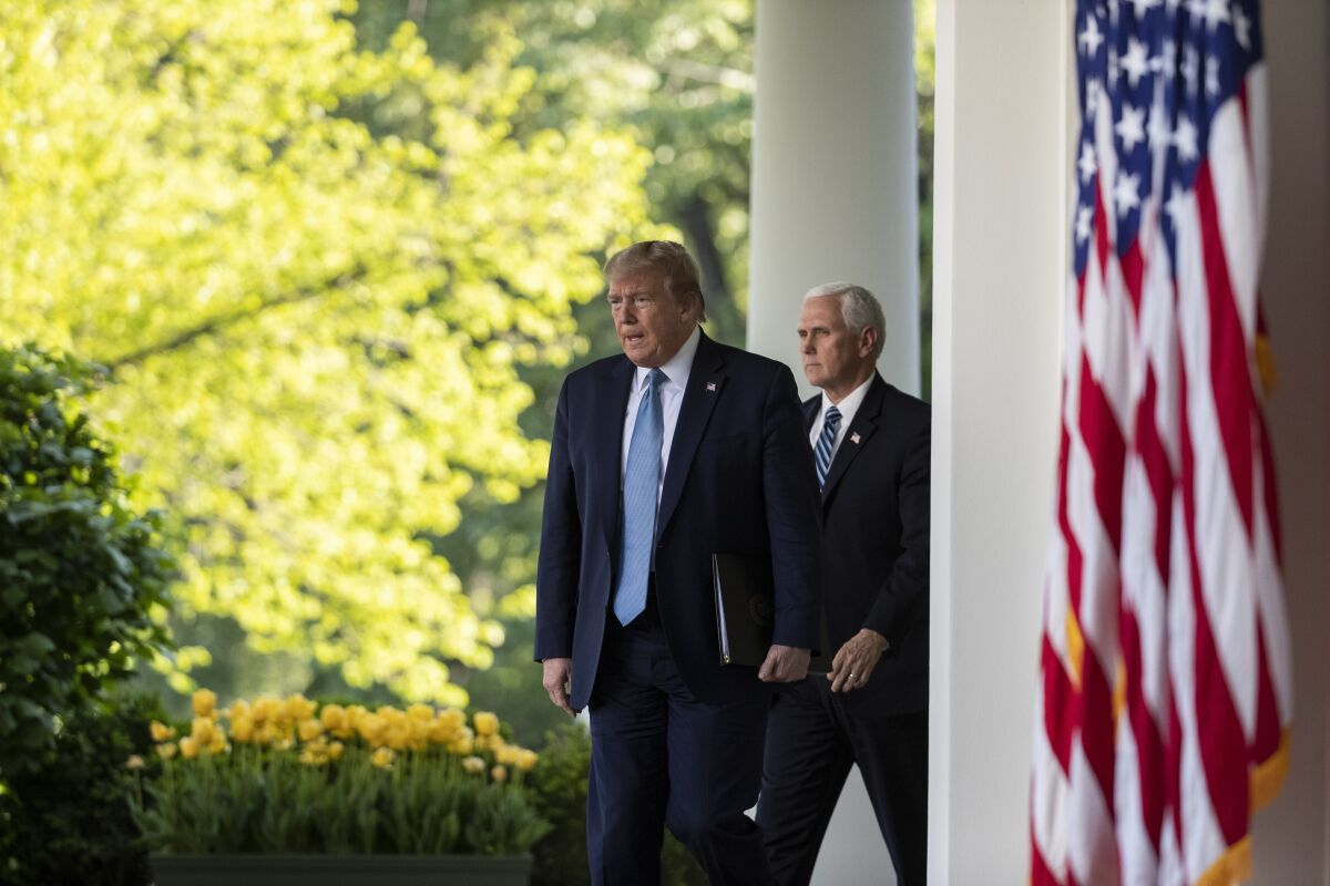 President Trump, with Vice President Mike Pence, walks to the White House Rose Garden for a coronavirus briefing on Wednesday.