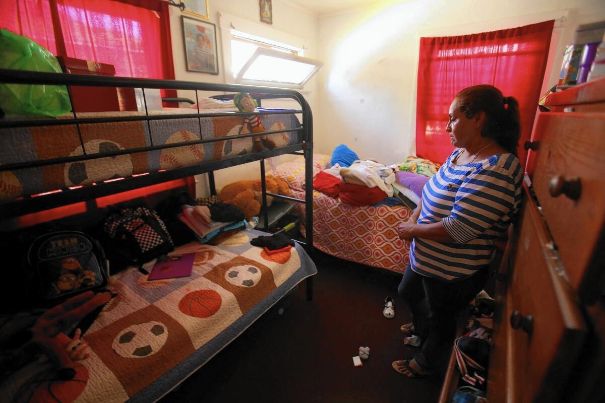 Josefina Barrales looks at the bunk beds where her stepsons Luis, Juan and Alexander Fuentes slept. The boys' father has been charged with murder in their stabbing deaths.
