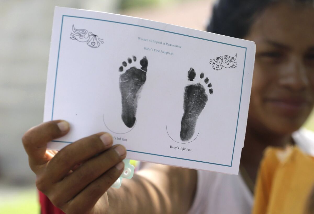 A woman in Sullivan City, Texas, who is in the country illegally, shows the footprints of her daughter who was born in the in the United State but was denied a birth certificate, on Sept. 16.
