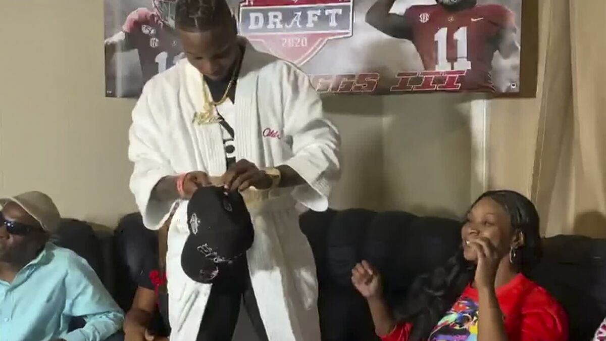 Alabama receiver Henry Ruggs III gets ready to put on a Las Vegas Raiders cap after being selected by the team during the first round of the 2020 NFL draft.