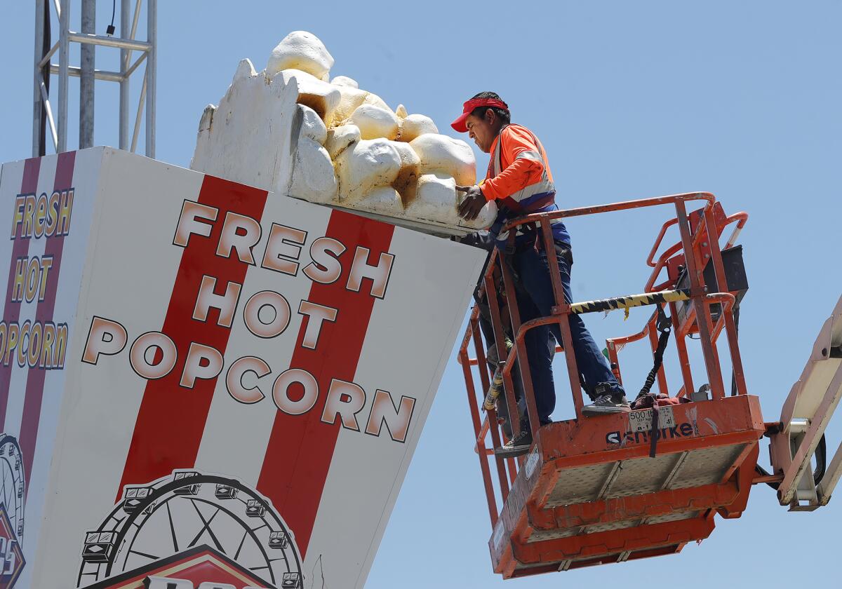 RCS workers assemble a giant popcorn container decoration for the Orange County Fair, "Happy Together," which opens Friday.