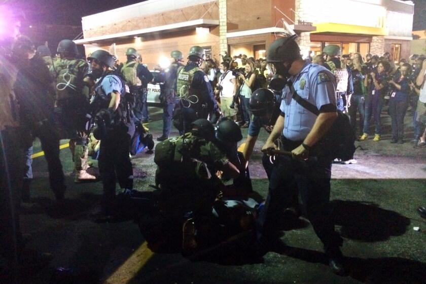 Police arrest a man in Ferguson, Mo., after someone threw a bottle.