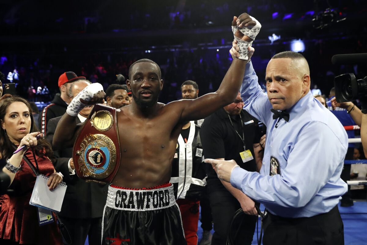 FILE - Terence Crawford has his hand raised in victory after defeating Lithuania's Egidijus Kavaliauskas by TKO in the ninth round of a WBO welterweight boxing match, Saturday, Dec. 14, 2019, in New York. Crawford is looking for a fight. The undefeated WBO welterweight champion has never fought less than twice in a calendar year as a professional. He faces the possibility of being idle all of 2020. (AP Photo/Michael Owens, File)