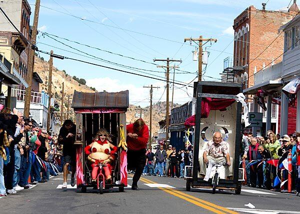 The Party Poopers, left, and the Pipers Opera House team run neck-and-neck in one of the Virginia City, Nev., heats. Each team includes one person to steer and two to push.