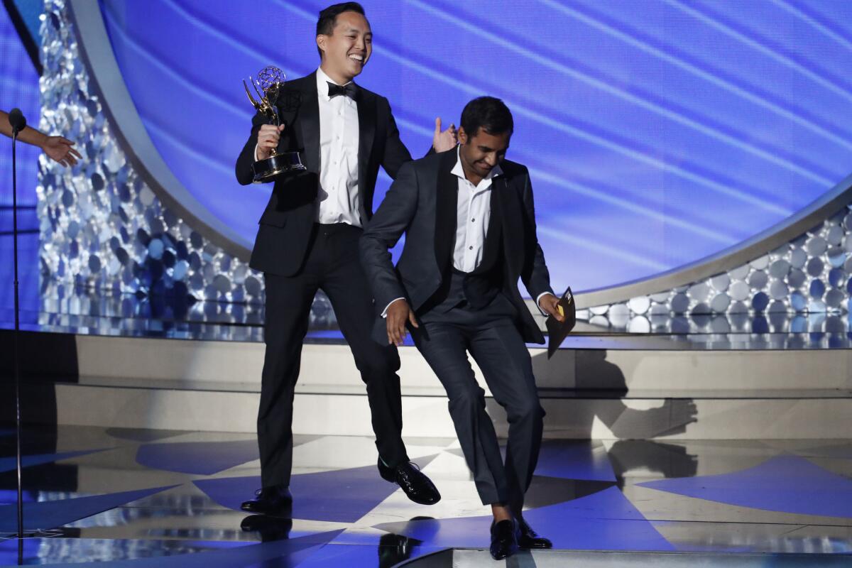 Alan Yang, left, accepts the Emmy for comedy writing with Aziz Ansari.