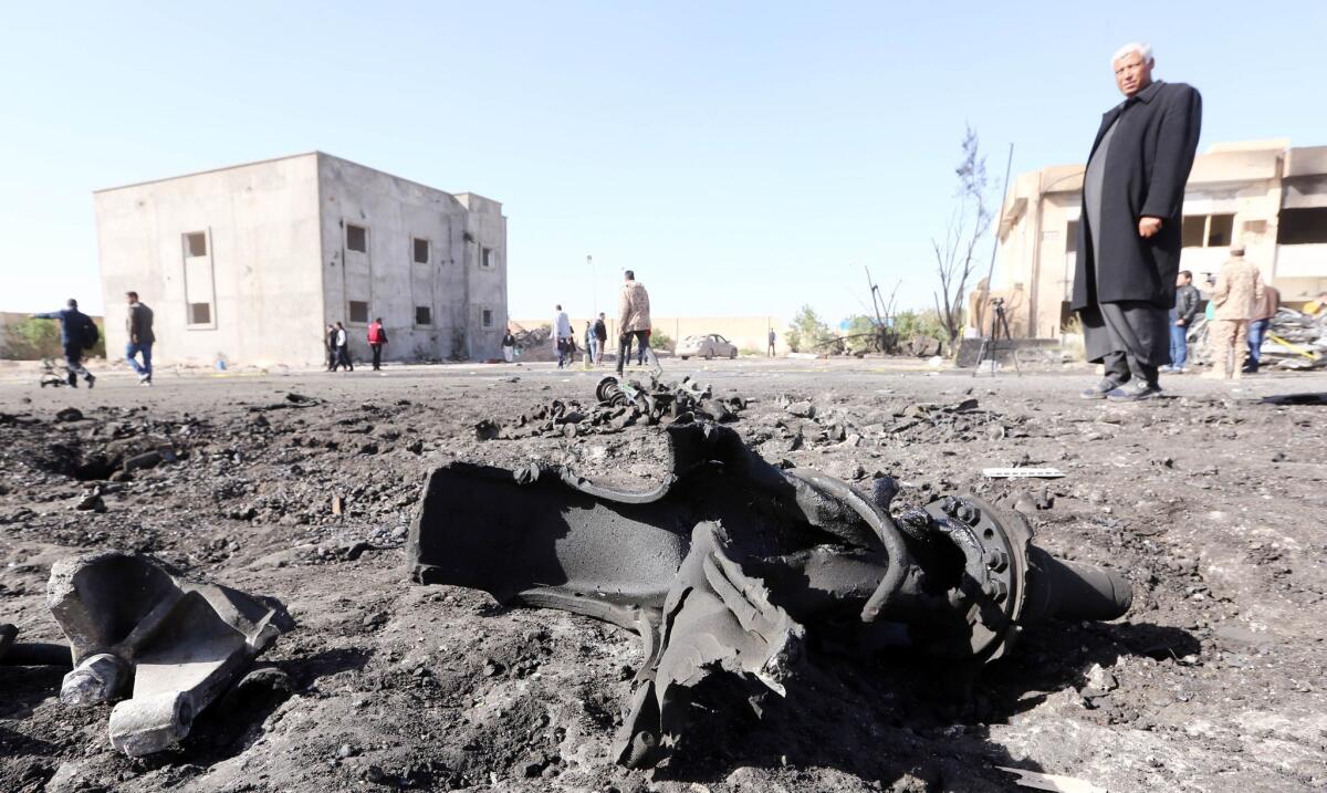 Libyans inspect the site of a suicide truck bombing on a police school in Libya's coastal city of Zlitan on Jan. 7.