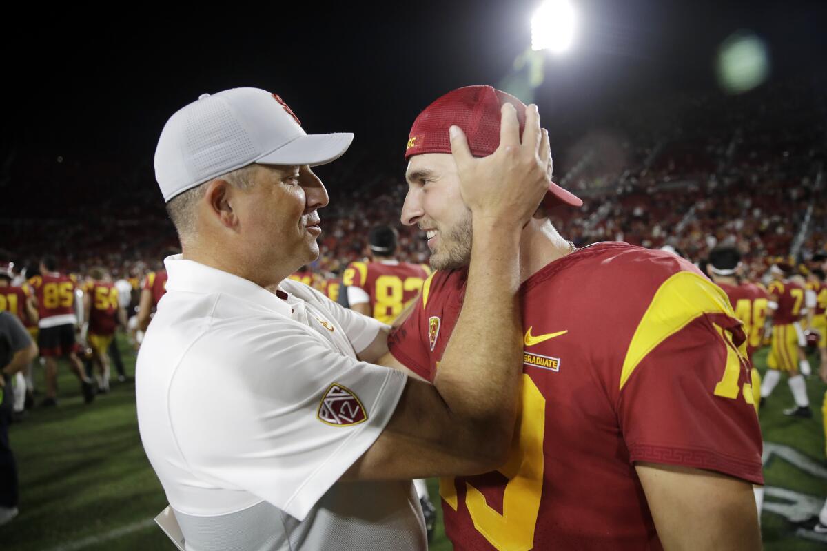 USC coach Clay Helton celebrates with quarterback Matt Fink after the team's 30-23 win over Utah on Friday.