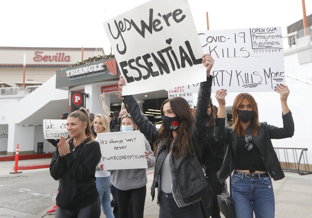 Demonstrators protest the stay-at-home order at Triangle Square in Costa Mesa.