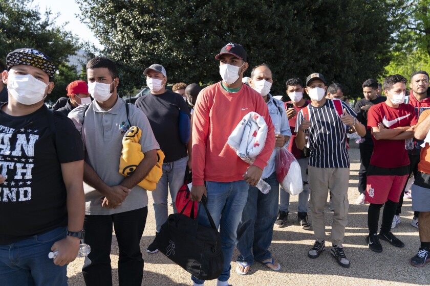 ARCHIVO - Migrantes llevan mantas de la Cruz Roja tras arribar en autobús a Union Station, cerca del Capitolio, desde Texas, el 27 de abril del 2022. (AP Foto/Jose Luis Magana)