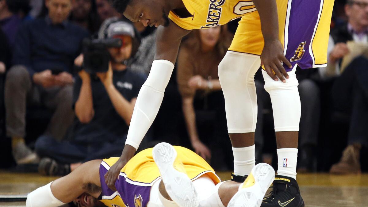 Lakers forward Julius Randle checks on injured guard D'Angelo Russell, who strained a ligament in his right knee during the first half.