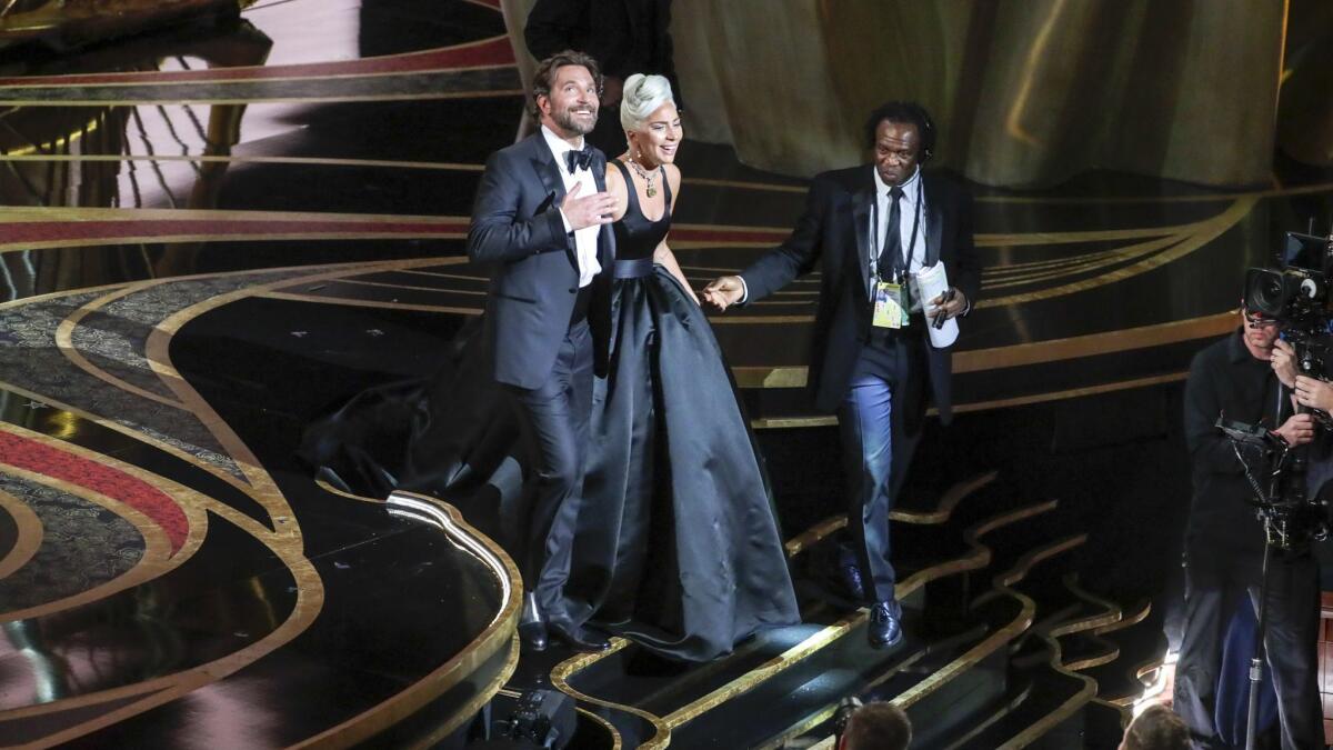 Gaga and Cooper walk back to their seats after their performance.