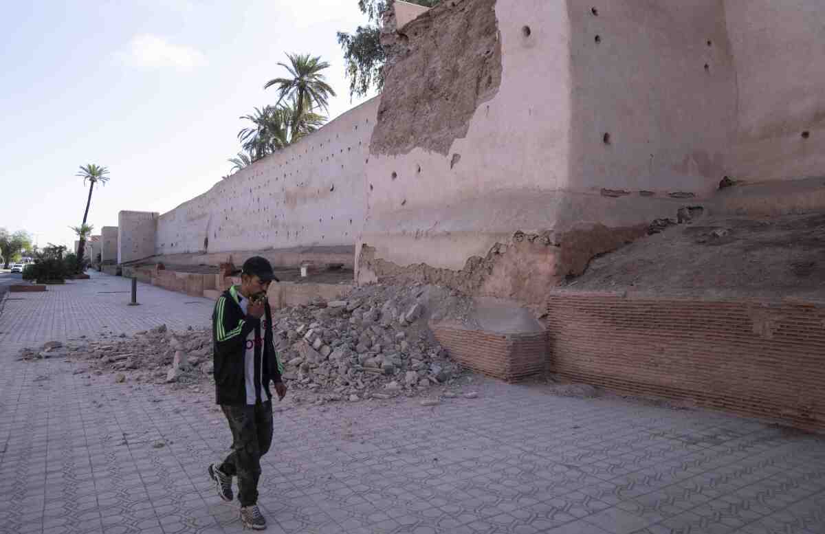 Un hombre pasa junto a un tramo dañado de la muralla de la histórica Medina de Marrakech 