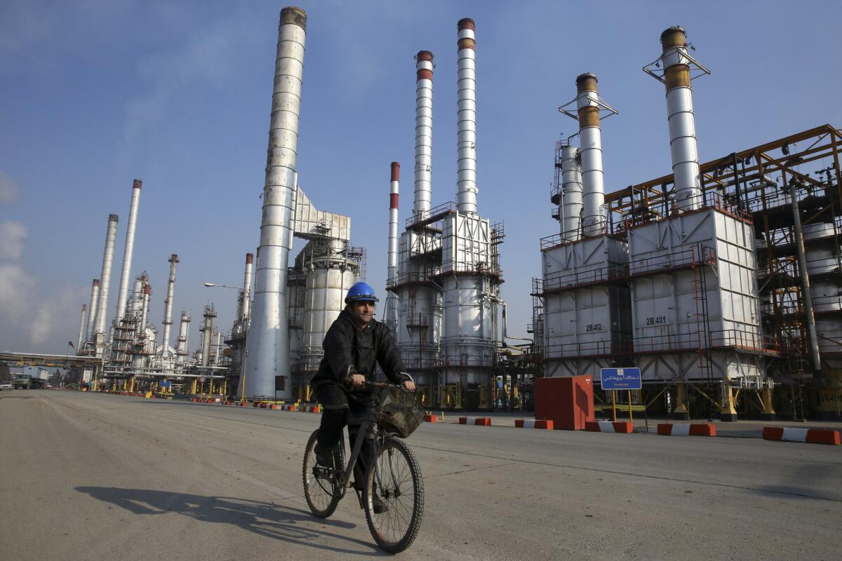 An Iranian oil worker rides a bicycle at a refinery south of Tehran in December 2014.