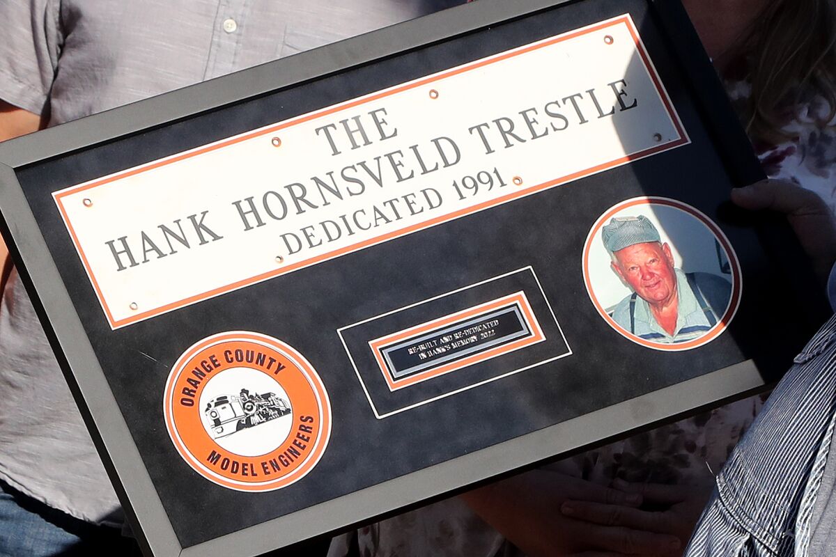 A plaque from when Hank Hornsveld completed the first trestle bridge in 1991 was presented to his grandchildren Tuesday. 