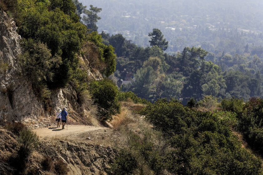 LA CANADA FLINTRIDGE, CA., OCTOBER 13, 2019: Hikers descend the long, steep Hall Beckley Canyon/Earl Canyon Mountainway trail in the Alta Canyada neighborhood of La Canada Flintridge providing grand vistas of neighboring communities. The trail is actually a 3.61- mile fire road with multiple switchbacks and viewpoints along the way October 13, 2019 (Mark Boster For the LA Times).