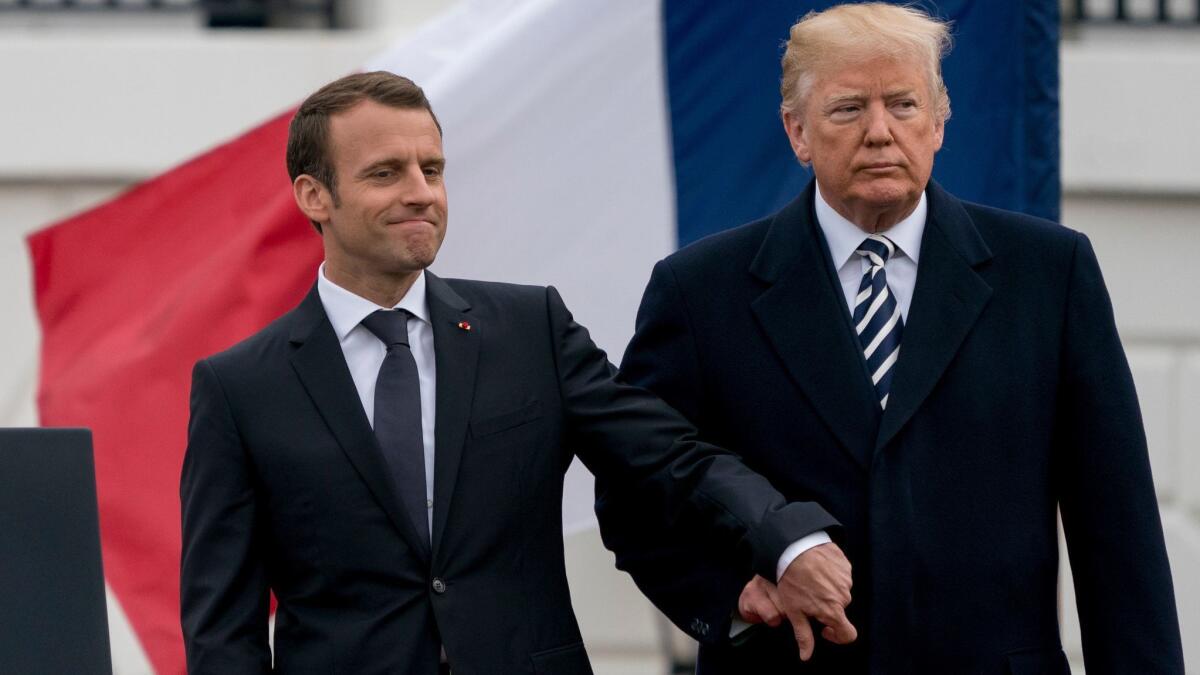 President Donald Trump and French President Emmanuel Macron hold hands during a State Arrival Ceremony on the South Lawn of the White House in Washington on April 24.
