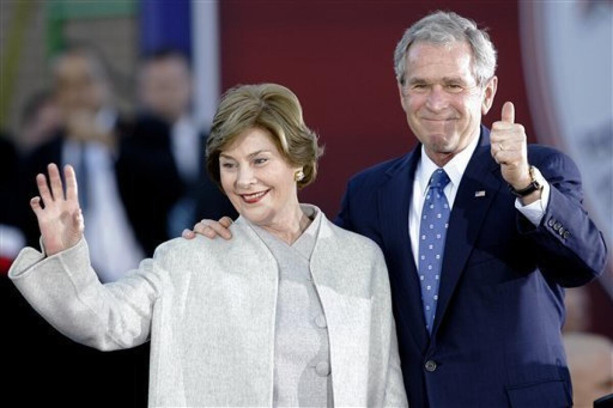 Former President George W. Bush and former first lady Laura Bush greet the crowd before a "Welcome Home" rally, Tuesday, Jan. 20, 2009, in Midland, Texas. (AP Photo/Matt Slocum)