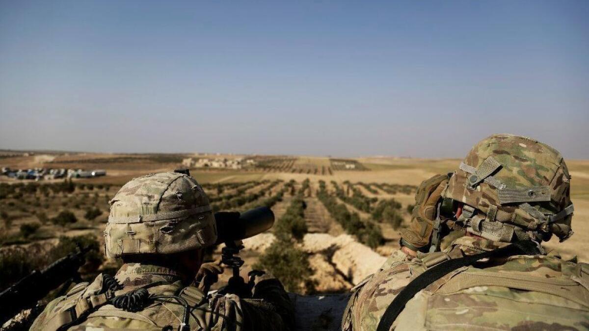 American troops look out in February toward the border with Turkey from a small outpost near the town of Manbij in northern Syria.
