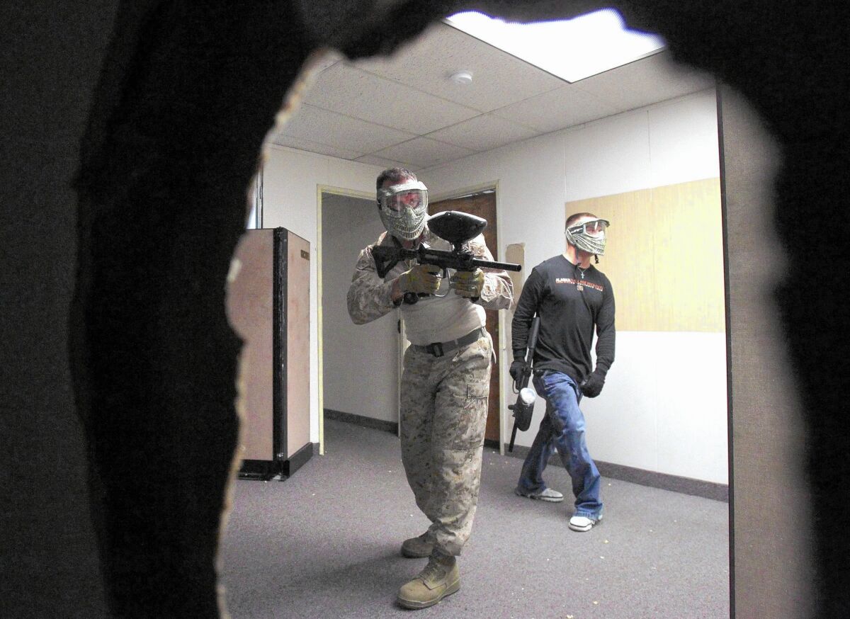 Warfighter Academy student Jason Perry (left) and instructor Joe Smith drill on close-quarters combat inside the new training center, which is the former Escondido Police Department headquarters on Grand Avenue.