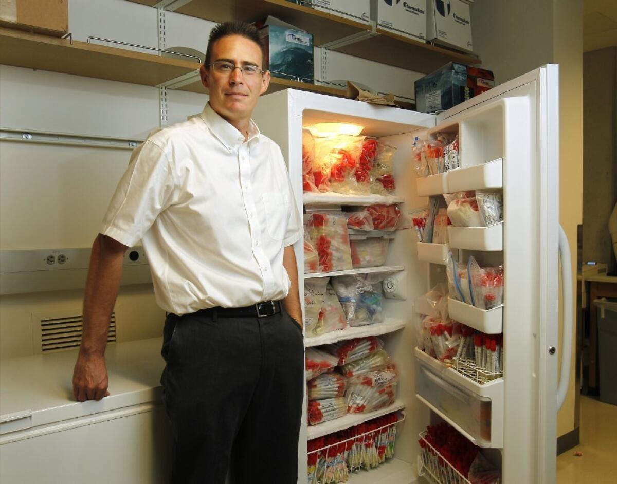 Rob Knight stands next to samples collected for his American Gut project. — K.C. Alfred