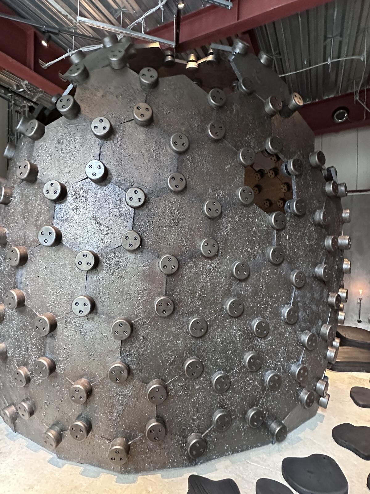 A giant sculptural orb made of wood and metal panels at Cokuun in Tokyo.