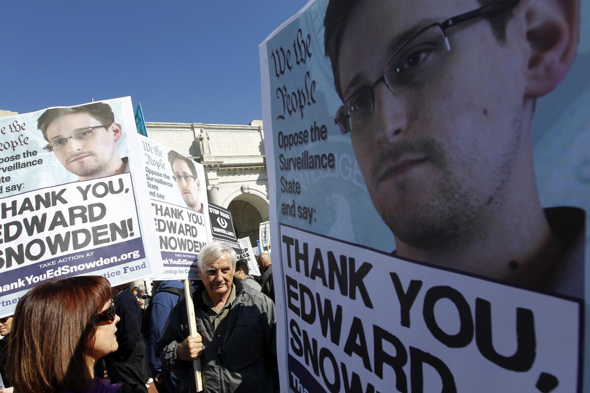 Demonstrators applaud NSA leaker Edward Snowden at a protest in Washington, D.C., on Saturday against broad NSA surveillance of Americans and U.S. allies.