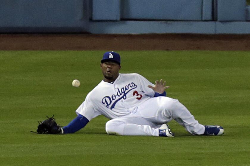 Dodgers left fielder Carl Crawford slides but can't catch an RBI triple by Padres left fielder Justin Upton during a game April 7 at Dodger Stadium.