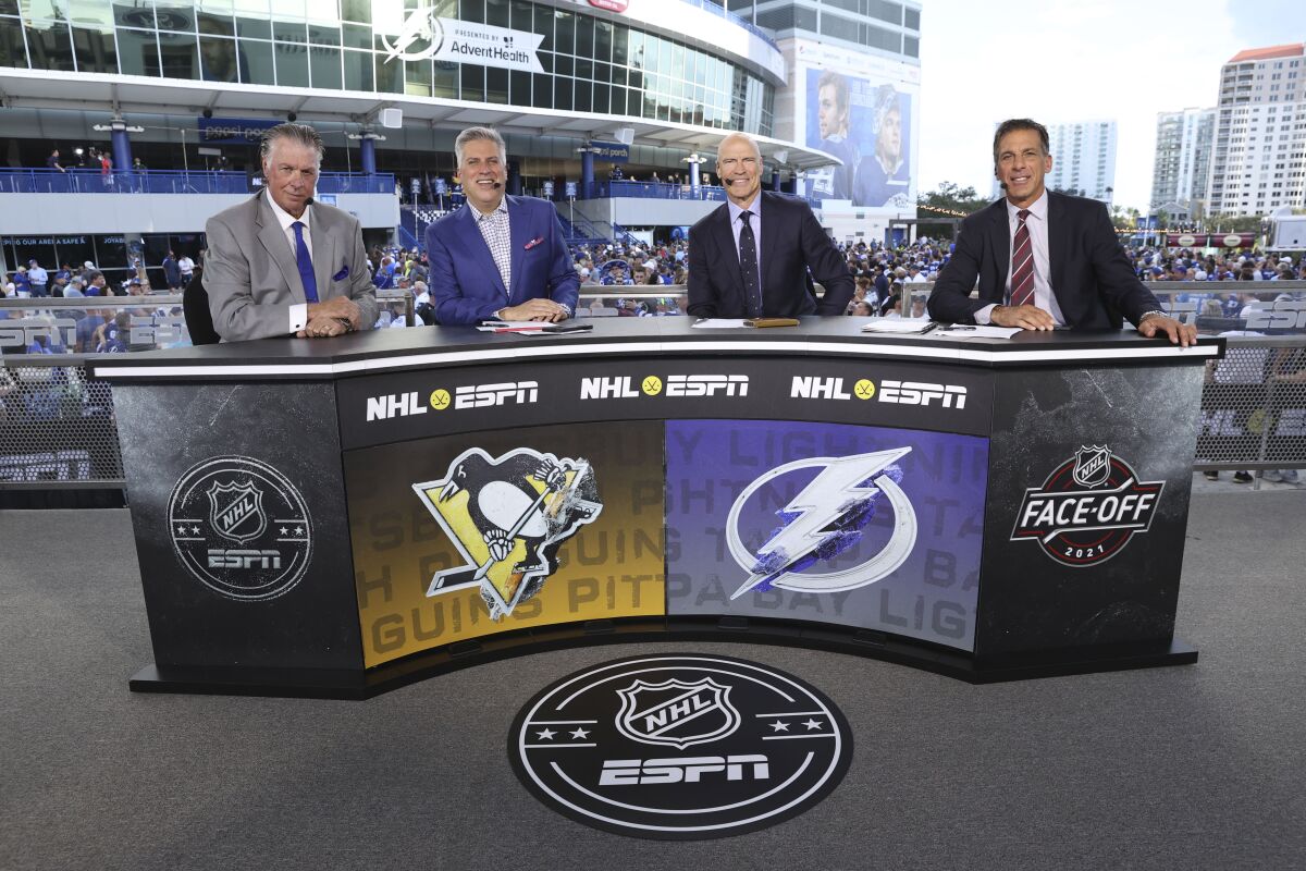 In this photo provided by ESPN Images, from left to right, ESPN’s Barry Melrose, Steve Levy, Mark Messier and Chris Chelios do a pregame segment at Amalie Arena in Tampa, Fla., before the Tampa Bay Lightning against the Pittsburgh Penguins NHL hockey game on Oct. 12, 2021. ESPN has returned to televising the NHL for the first time since 2004, but the All-Star Game, Saturday, Feb. 5, 2022, in Las Vegas begins a stretch where more games will be available on ABC and ESPN. (Allen Kee/ESPN Images via AP)