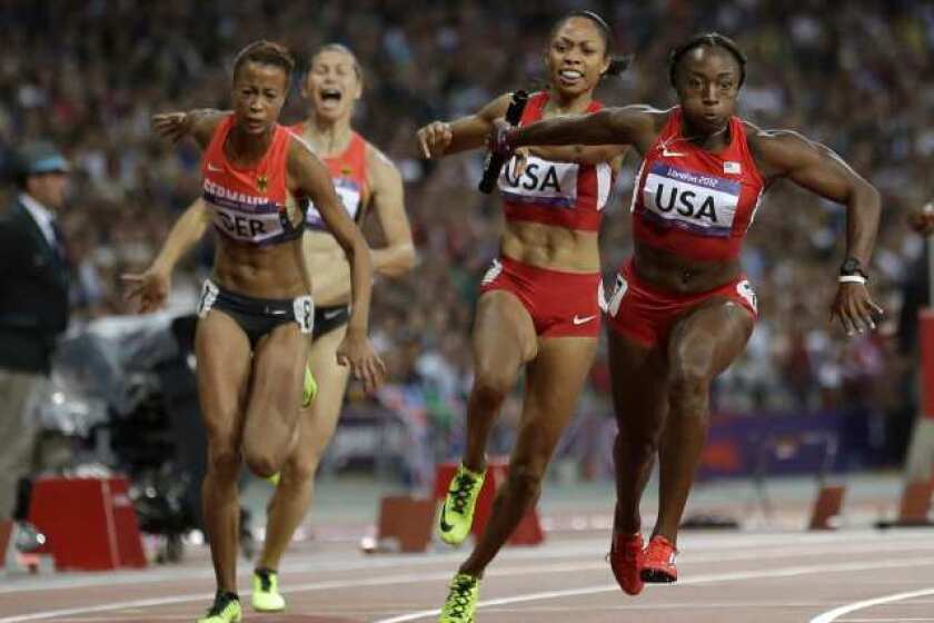 Bianca Knight, right, takes the baton from U.S. teammate Allyson Felix in the women's 400-meter relay final.