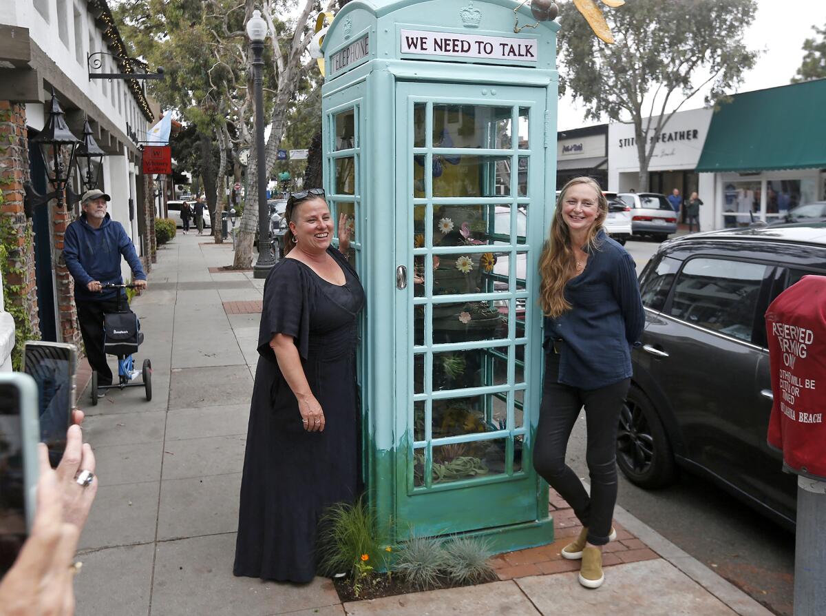 Artists Julie Setterholm and Candice Brokenshire, from left, stand at their public art installation in downtown Laguna Beach.